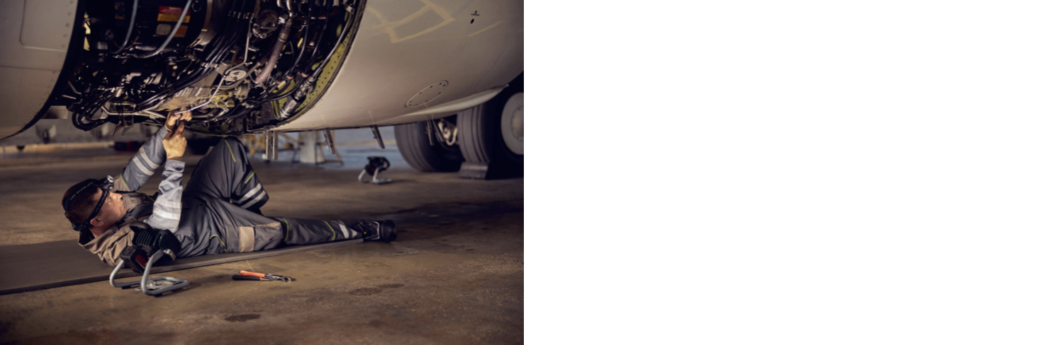 Mechanic working under an aircraft engine
